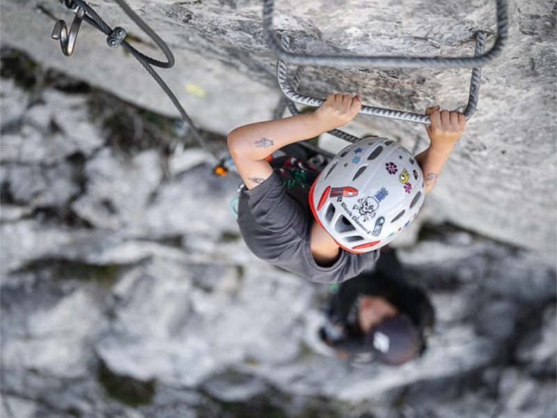 Enfant progressant sur des échelons métalliques lors d’une Via Ferrata famille à Saint-Paul-de-Fenouillet.