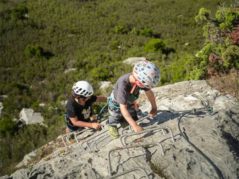 Enfants grimpant sur une paroi équipée lors d’une sortie Via Ferrata famille La Pichona à Saint-Paul-de-Fenouillet.