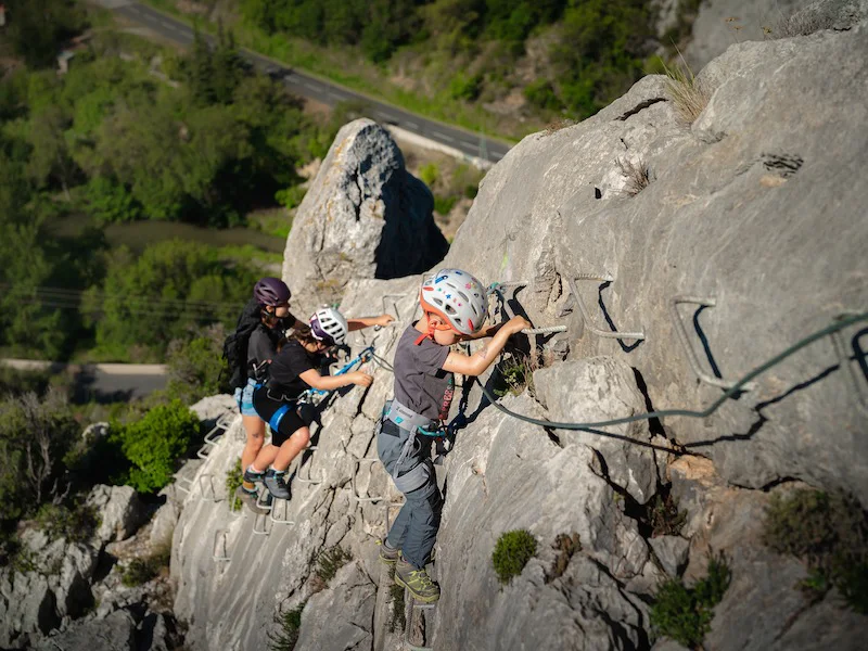 Famille avançant sur une paroi équipée lors d’une sortie Via Ferrata La Pichona à Saint-Paul-de-Fenouillet.