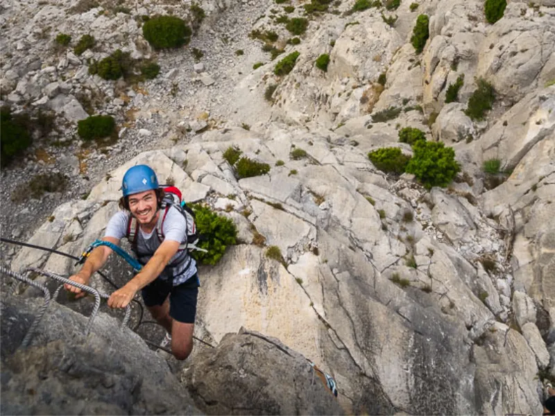 Participant grimpant sur une section verticale de la Via Ferrata La Panoramique à Saint-Paul-de-Fenouillet.