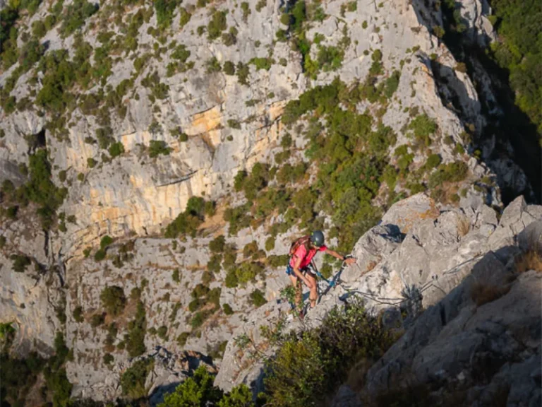 Participante évoluant sur une paroi rocheuse lors de la Via Ferrata La Panoramique dans les Pyrénées-Orientales.
