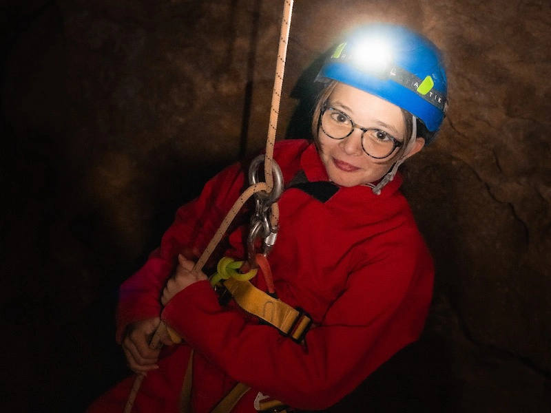 Enfant descendant en rappel dans une grotte lors d’une sortie spéléologie dans les Pyrénées-Orientales