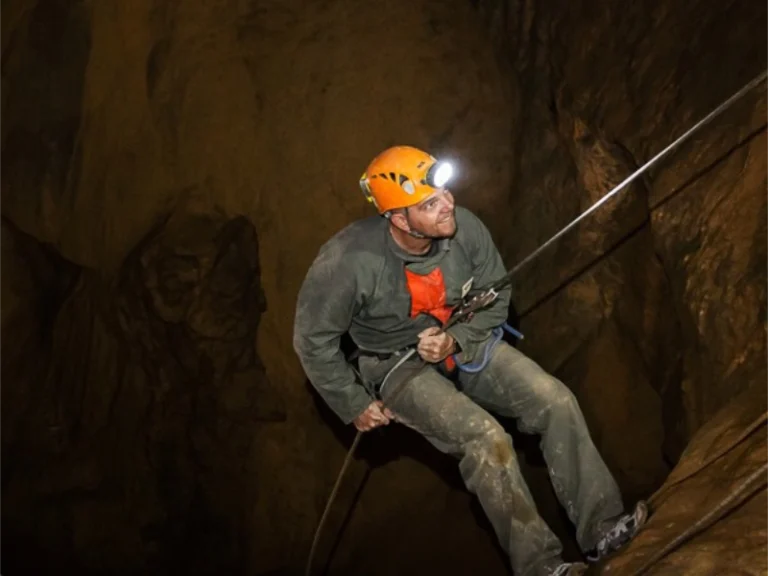Spéléologue descendant en rappel dans une grotte des gorges de Galamus lors d’une sortie spéléologie dans les Pyrénées-Orientales