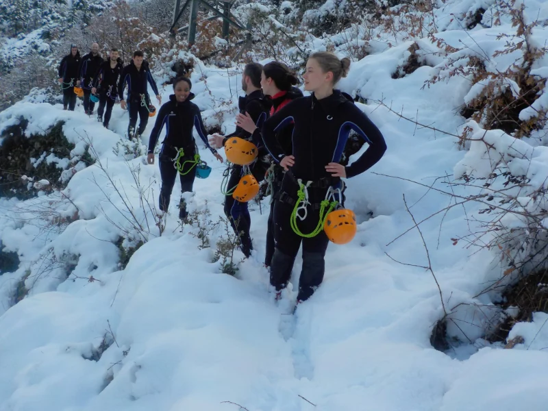 Groupe de participants marchant dans la neige lors de l’approche du canyon d’eau chaude de Thuès dans les Pyrénées-Orientales près de Font-Romeu