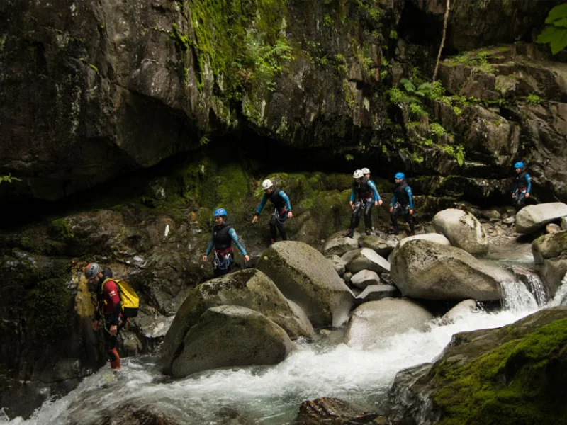 Groupe de participants progressant entre les rochers dans le canyon de Marc en Ariège lors d’une sortie canyoning dans la vallée de Vicdessos
