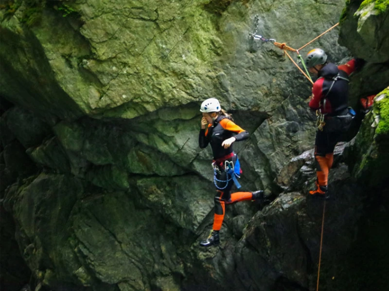 Participant sautant dans une vasque du canyon de Marc en Ariège sous la supervision d’un guide canyoning dans la vallée de Vicdessos