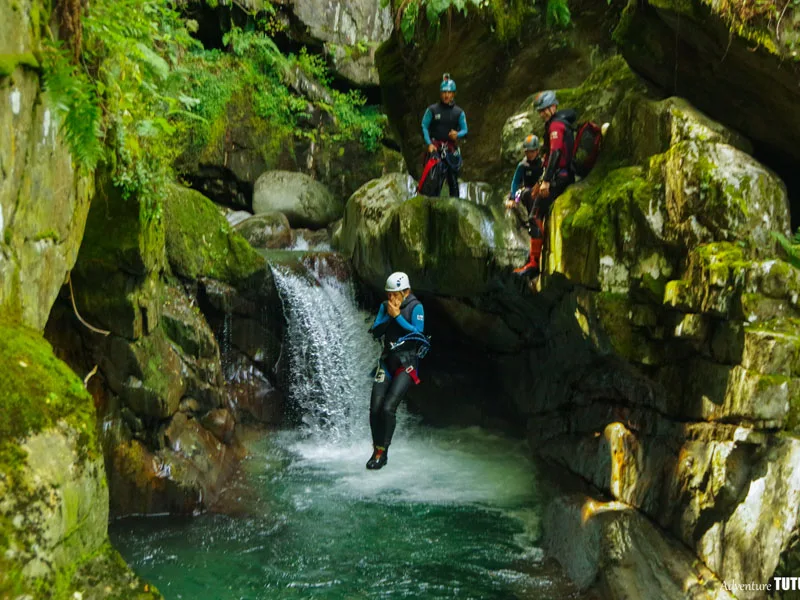 Participant sautant dans une vasque du canyon de Marc en Ariège pendant une sortie canyoning en groupe dans la vallée de Vicdessos