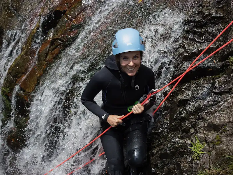 Pratiquante en descente en rappel dans une cascade du canyon du Baousous à Céret dans les Pyrénées-Orientales