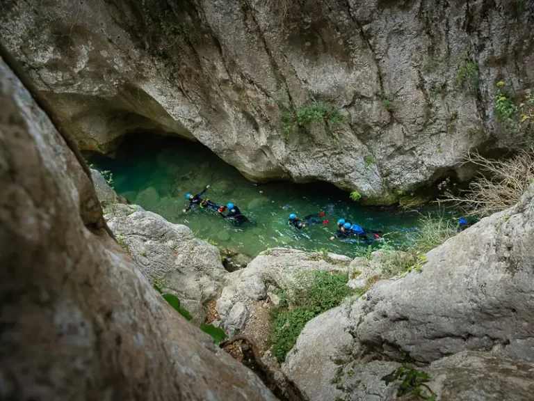 Participants nageant dans une vasque encaissée lors d’une sortie canyoning dans le canyon de Galamus dans le massif des Corbières