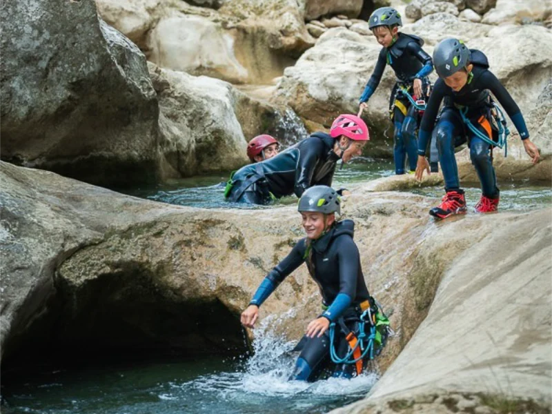 Groupe de jeunes participants progressant dans la rivière lors d’une sortie canyoning dans les gorges de Galamus dans les Corbières
