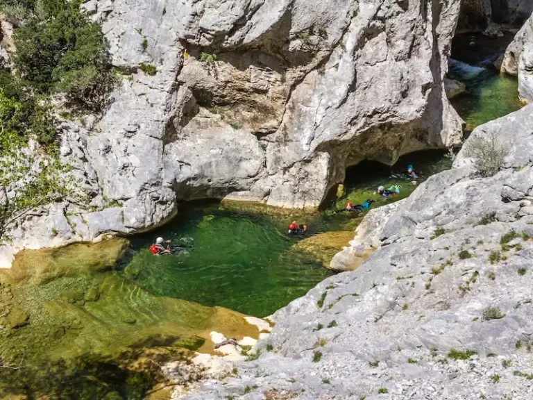 Participants nageant dans une vasque d’eau turquoise lors d’une sortie canyoning dans le canyon de Galamus dans les Pyrénées-Orientales