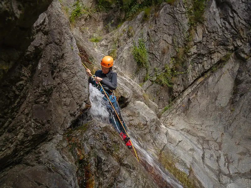 Participant descendant en rappel une cascade dans le canyon des Anelles à Céret dans les Pyrénées-Orientales