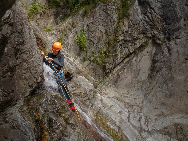 participant descendant en rappel une cascade lors d’une sortie canyoning dans les Pyrénées-Orientales
