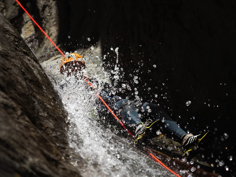 Participant descendant en rappel sous une cascade dans le canyon des Anelles à Céret dans les Pyrénées-Orientales