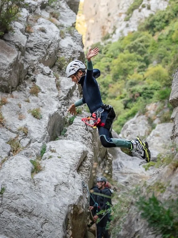 Participant sautant dans un passage étroit lors d’une sortie canyoning dans le canyon de Galamus près de Saint-Paul-de-Fenouillet
