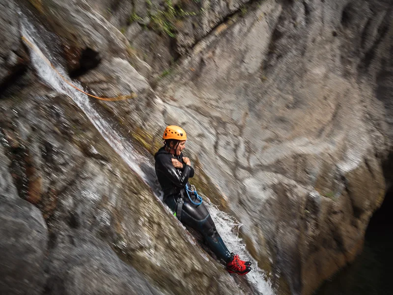Participant descendant un toboggan naturel dans le canyon des Anelles à Céret dans les Pyrénées-Orientales lors d’une sortie canyoning