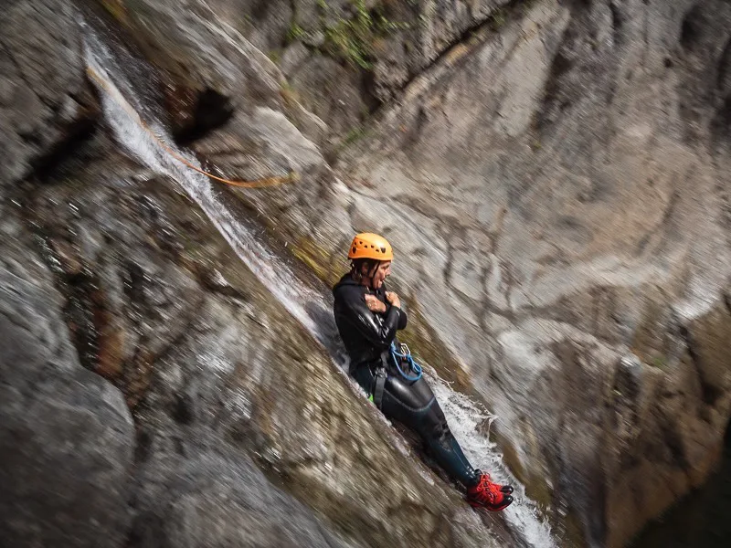 participant descendant un toboggan naturel lors d’une sortie canyoning dans les Pyrénées-Orientales