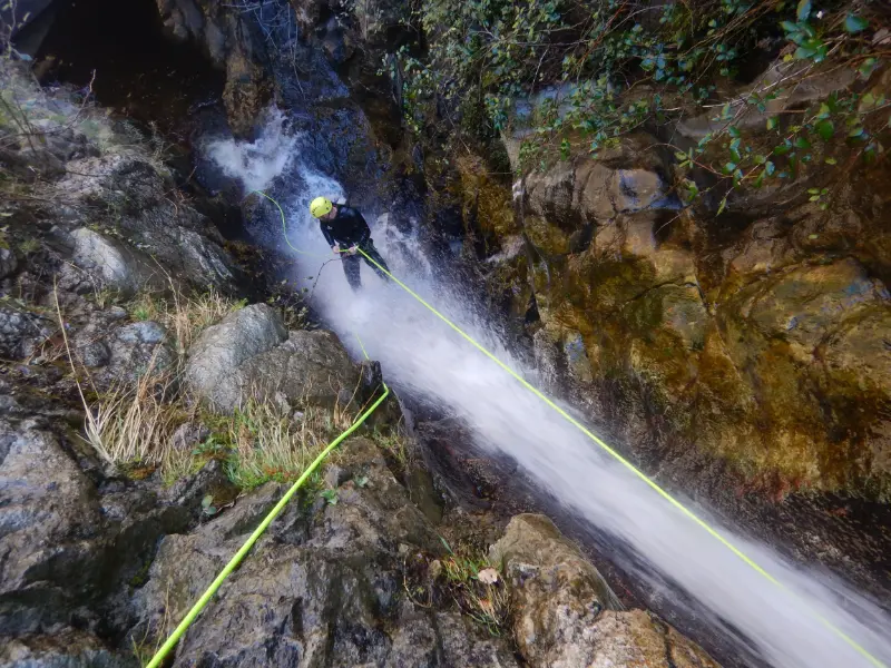 Pratiquant descendant en rappel dans une cascade du canyon d’eau chaude de Thuès lors d’une sortie canyoning hivernale dans les Pyrénées-Orientales près de Font-Romeu