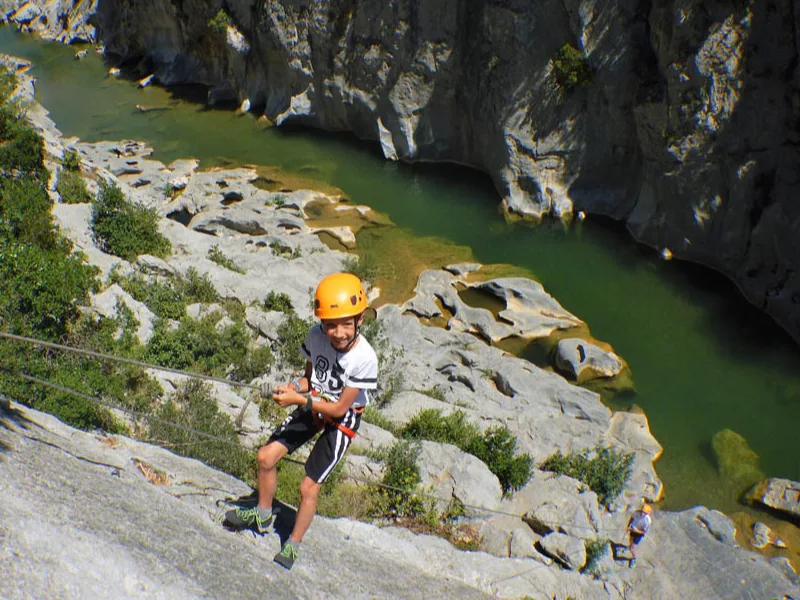 enfant pratiquant l’escalade sur une falaise dans les Pyrénées-Orientales