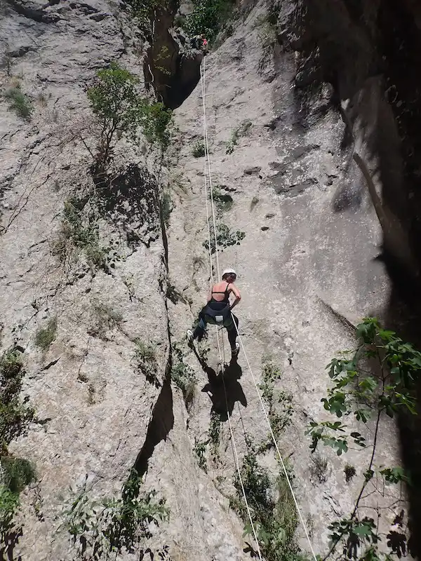 Participant descendant un grand rappel dans le canyon de l’Ermitage dans les gorges de Galamus près de Saint-Paul-de-Fenouillet