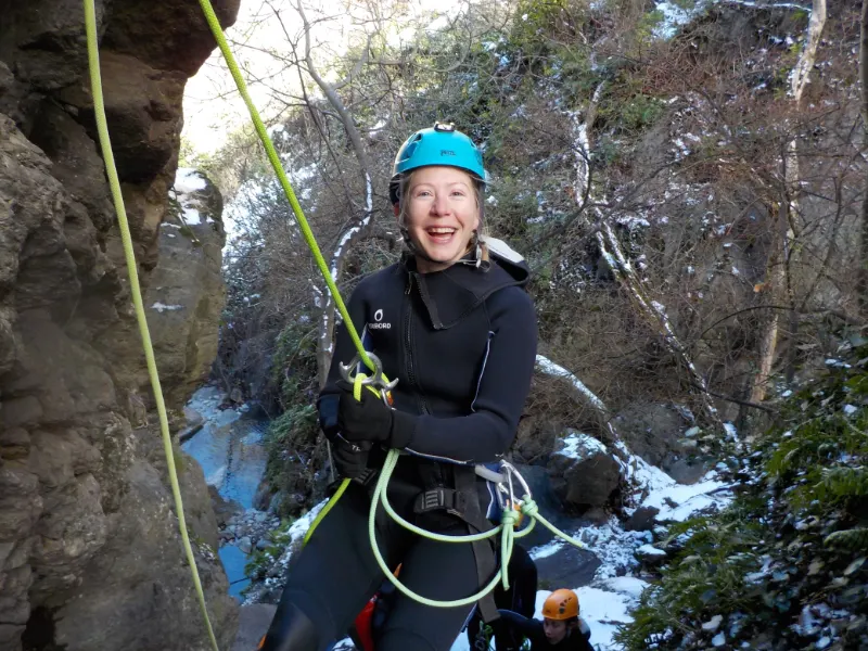 Pratiquante descendant en rappel dans le canyon d’eau chaude de Thuès lors d’une sortie canyoning hivernale dans les Pyrénées-Orientales