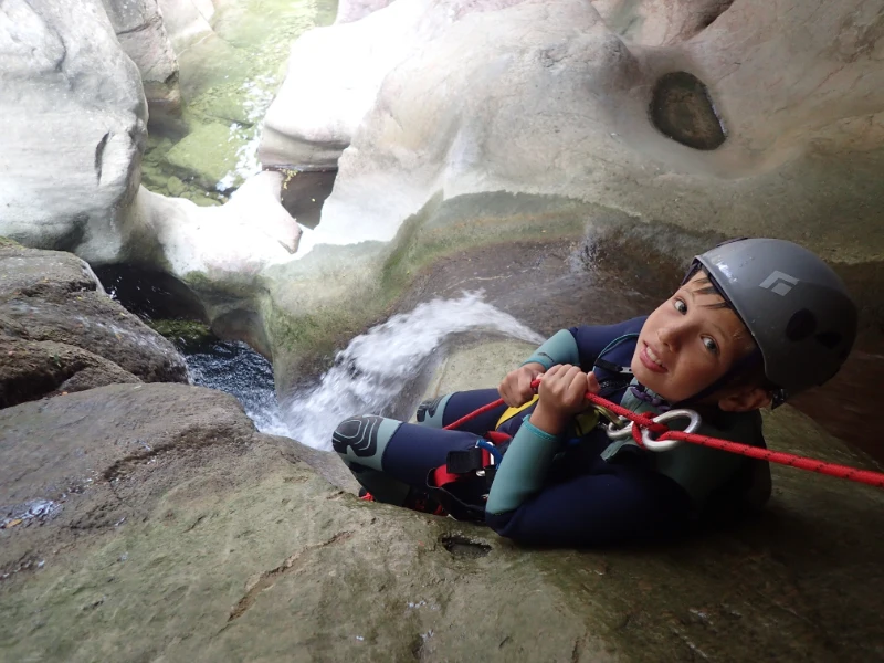 Jeune participant descendant en rappel dans une cascade lors d’une sortie canyoning dans les Gorges du Terminet à Termes dans l’Aude