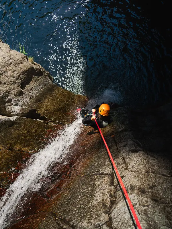 Participant en canyoning descendant en rappel une cascade dans le canyon des Anelles à Céret dans les Pyrénées-Orientales