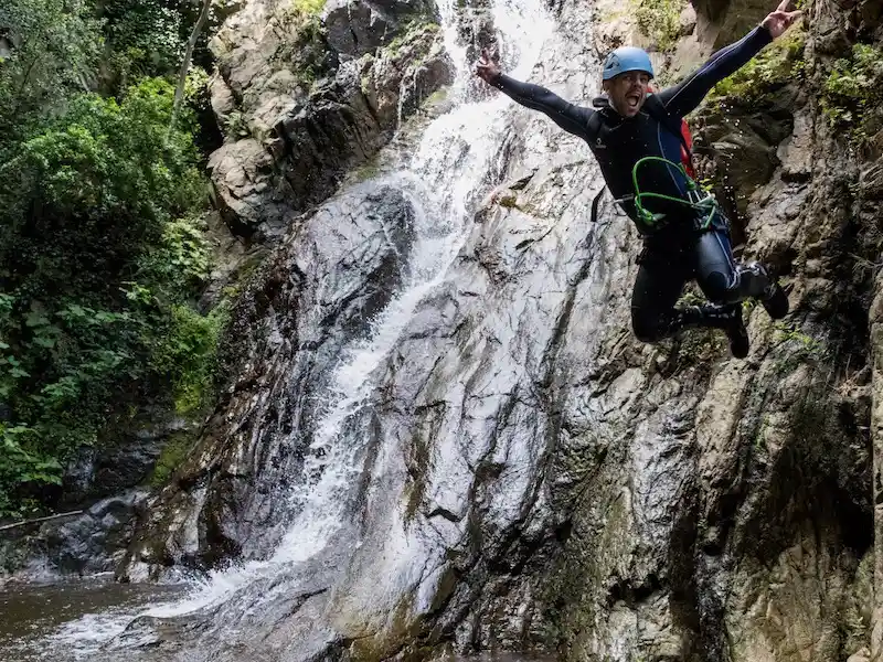 Pratiquant réalisant un saut dans une vasque au pied d’une cascade dans le canyon du Baousous à Céret dans les Pyrénées-Orientales