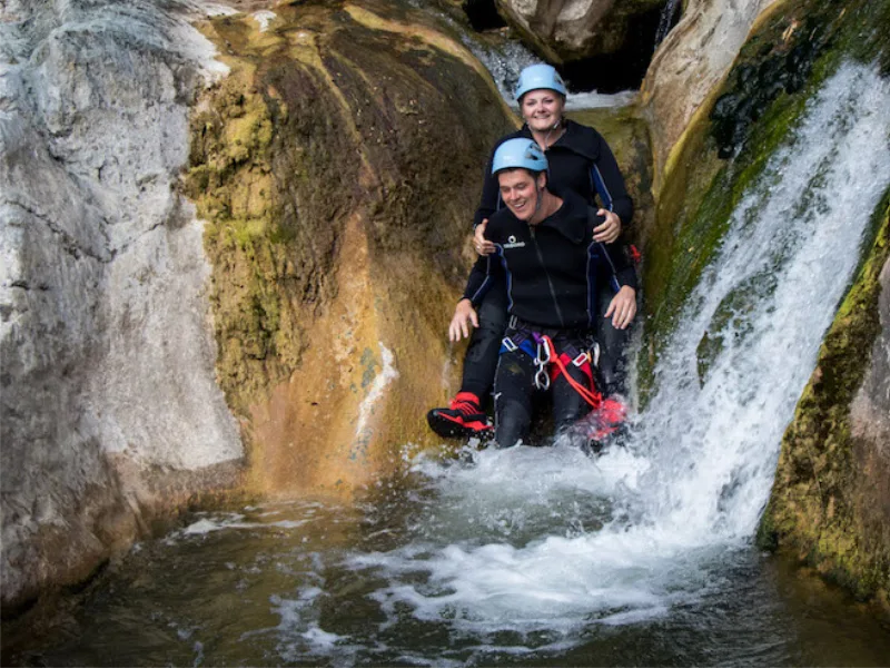 Participants descendant un toboggan naturel lors d’une sortie canyoning dans les Gorges du Terminet à Termes dans l’Aude
