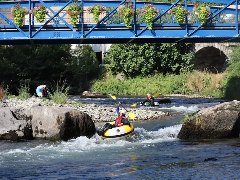 Participant en tubing sur la rivière Aude franchissant un rapide